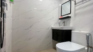 Een badkamer met toilet, wastafel en douche.