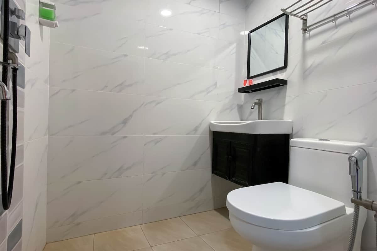 Een badkamer met toilet, wastafel en douche.