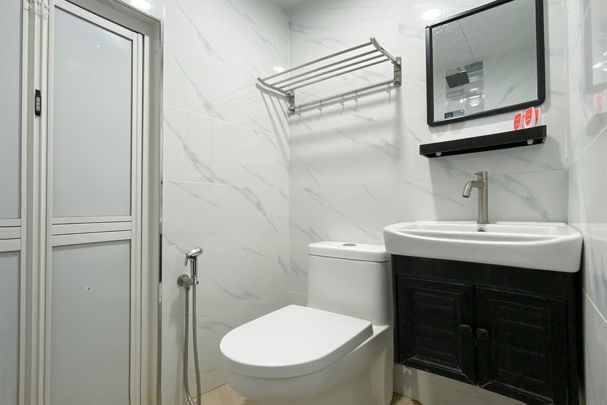 Een badkamer met toilet, wastafel en douche.