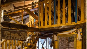 A rustic wooden interior with a staircase, rustic decor, and a dining area.