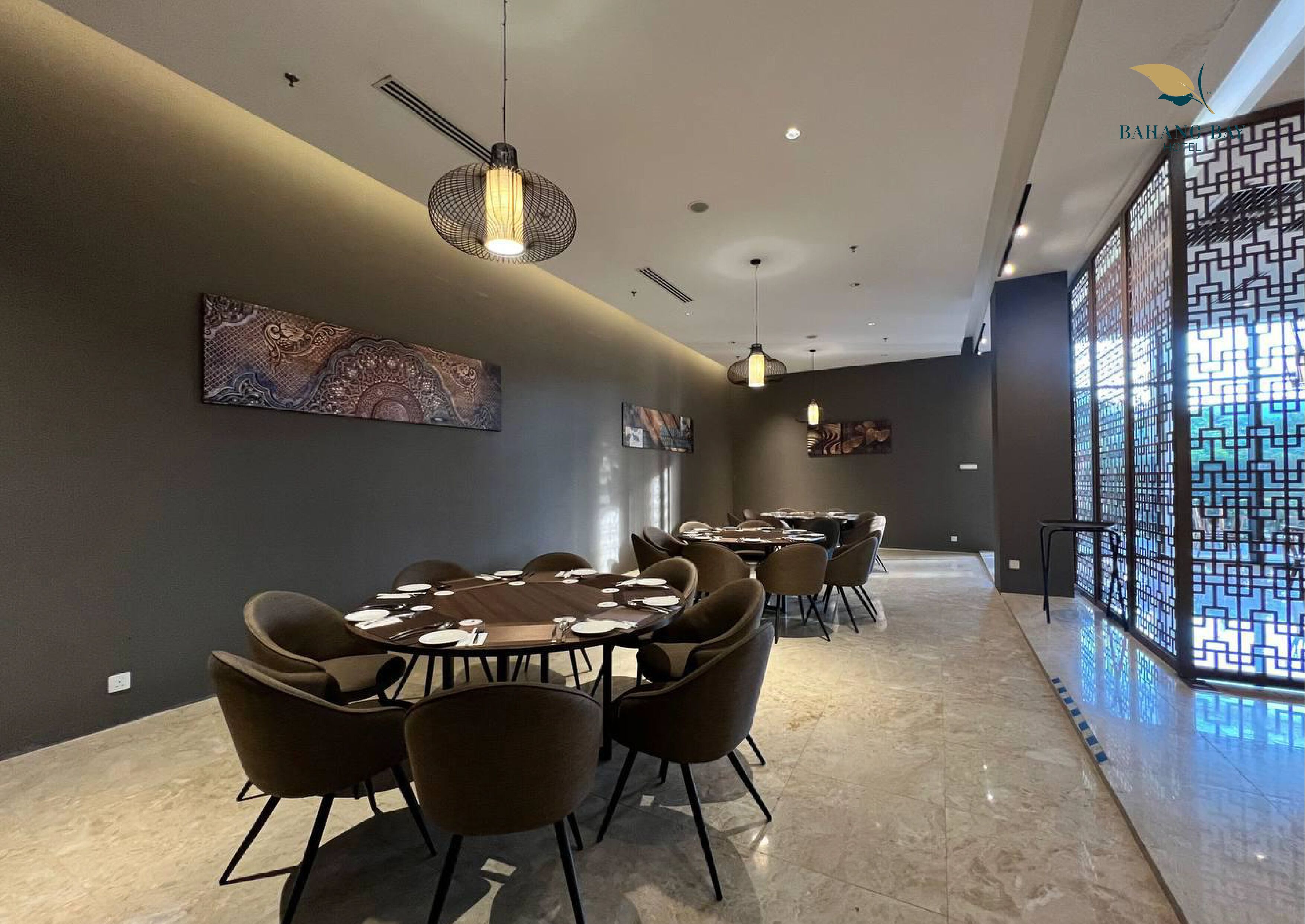 Un comedor moderno con mesas y sillas redondas, iluminación colgante y decoración en la pared.