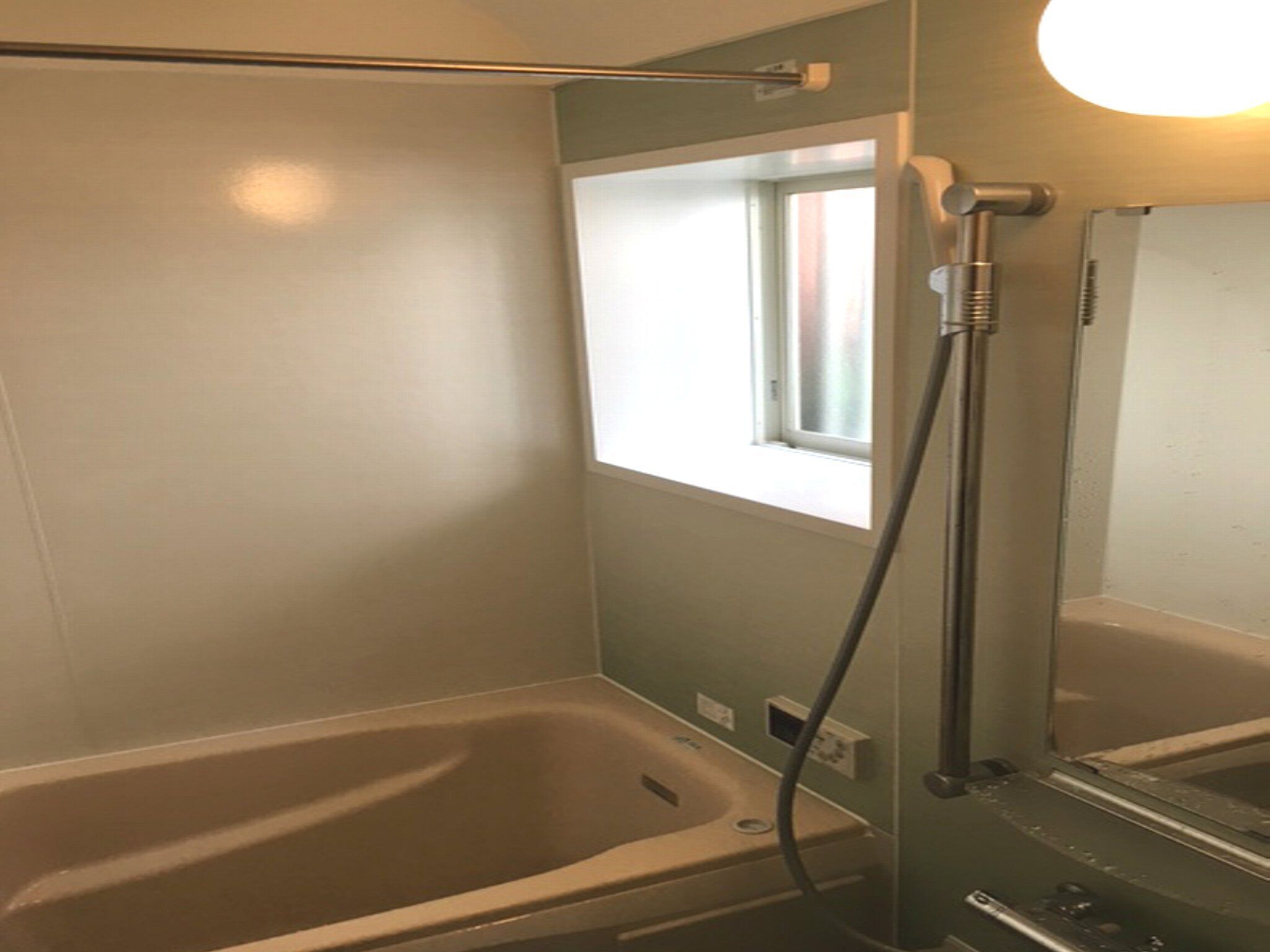 Un baño con bañera, ventana y ducha.