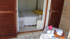 Un dormitorio con cama, mesita de noche y una mesa con juego de té.