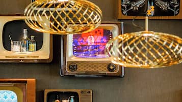 A wall with vintage televisions displaying various items.