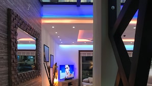A modern living room with a flat-screen TV, a fireplace, and a decorative vase. - Luxury Duplex  2 MIN to 5th , Beach & Tourist Aera (Playa del Carmen)