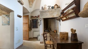 Une cuisine rustique avec une cheminée en pierre, des meubles en bois et une carte accrochée au mur.