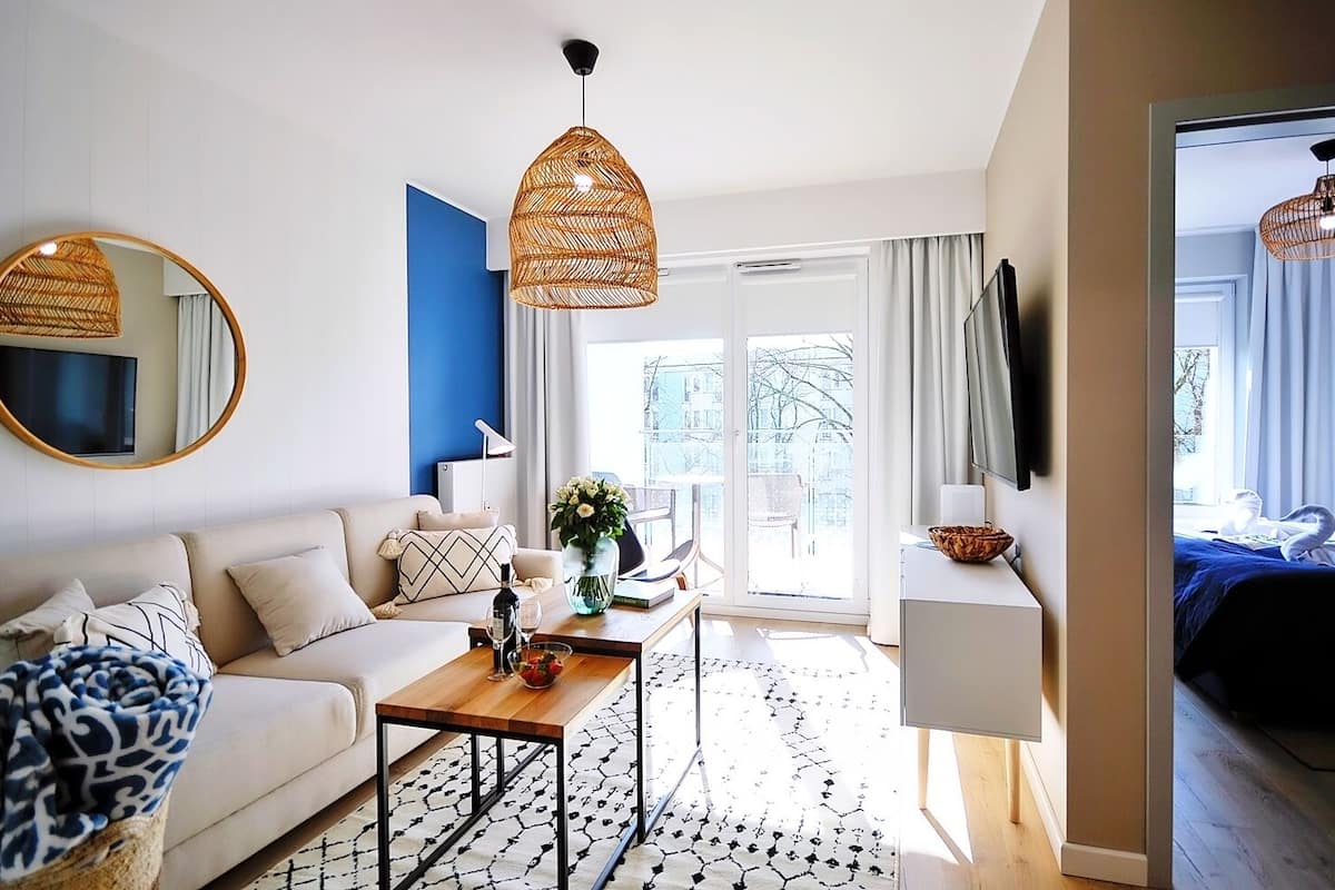 Ein modernes Hotelzimmer mit einer Couch, einem Couchtisch und Blick auf die Stadt.