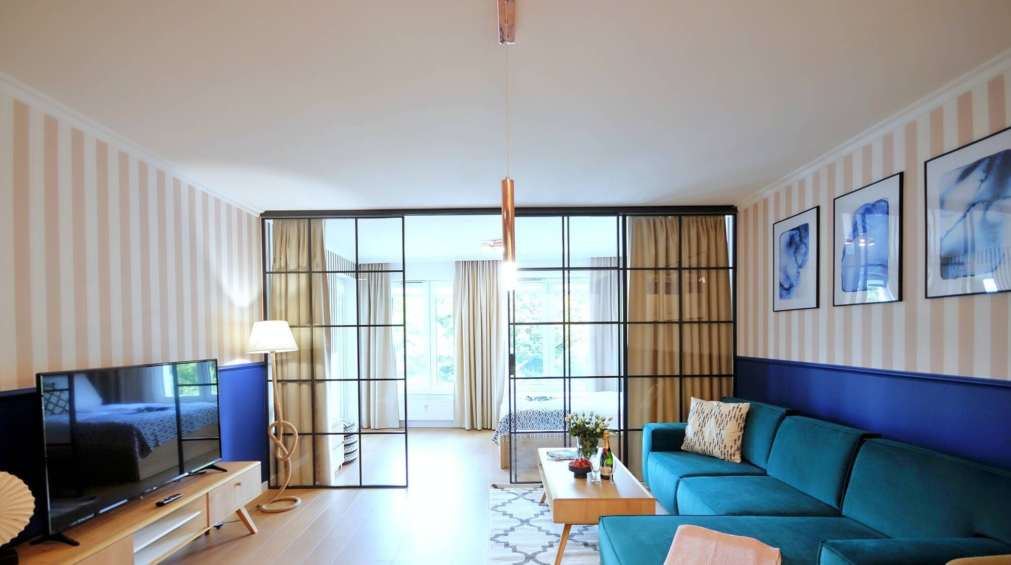 A modern living room with a large TV, a sofa, and a dining area.