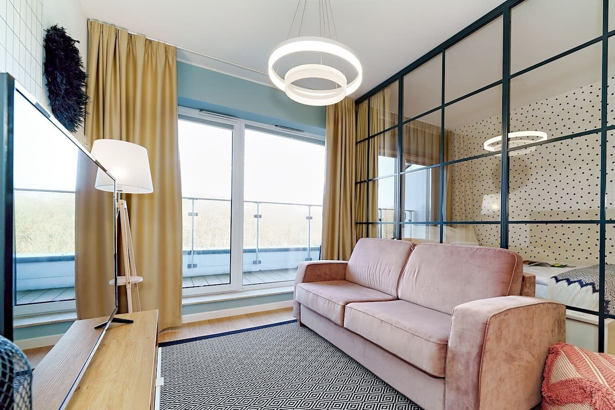 Ein modernes Wohnzimmer mit einer Couch, einer Lampe und einem gemusterten Teppich.