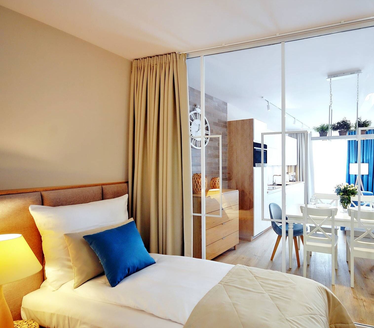 A hotel room with a bed, a desk, and a view of the outside.