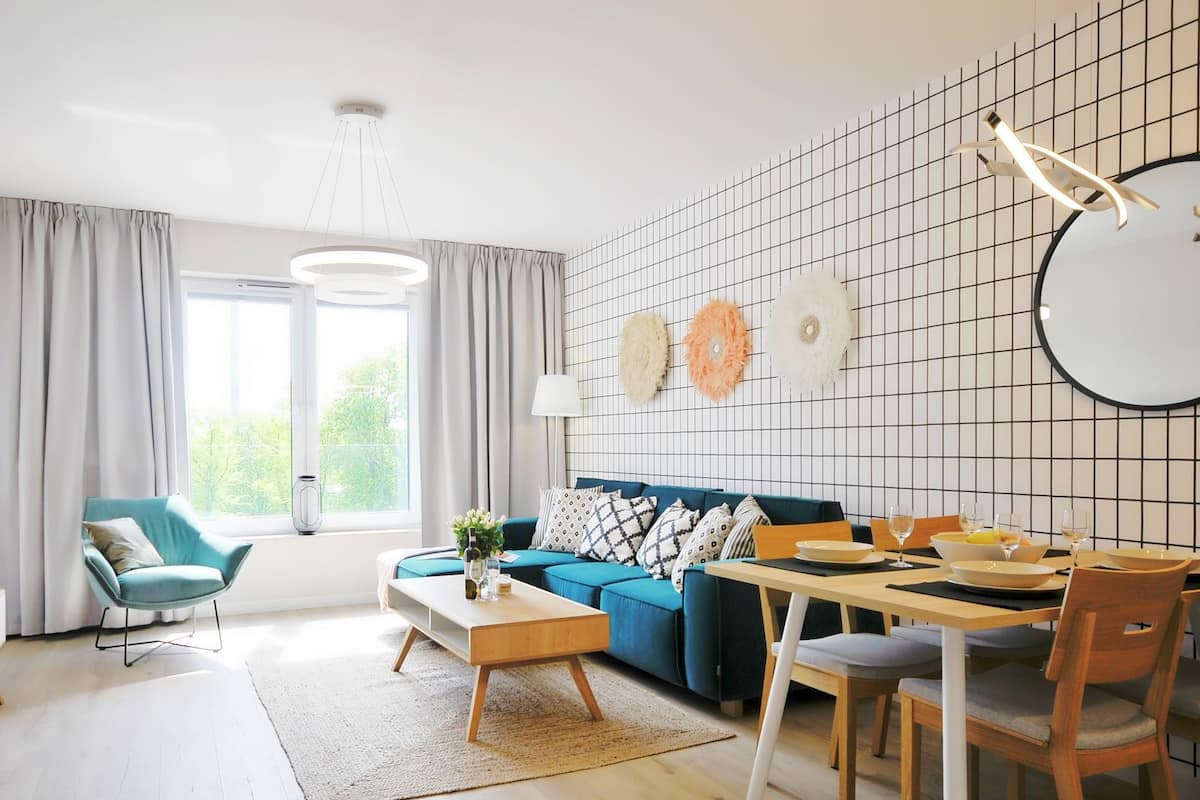 Ein modernes Wohnzimmer mit Sofa, Couchtisch, Fernseher und Essbereich.
