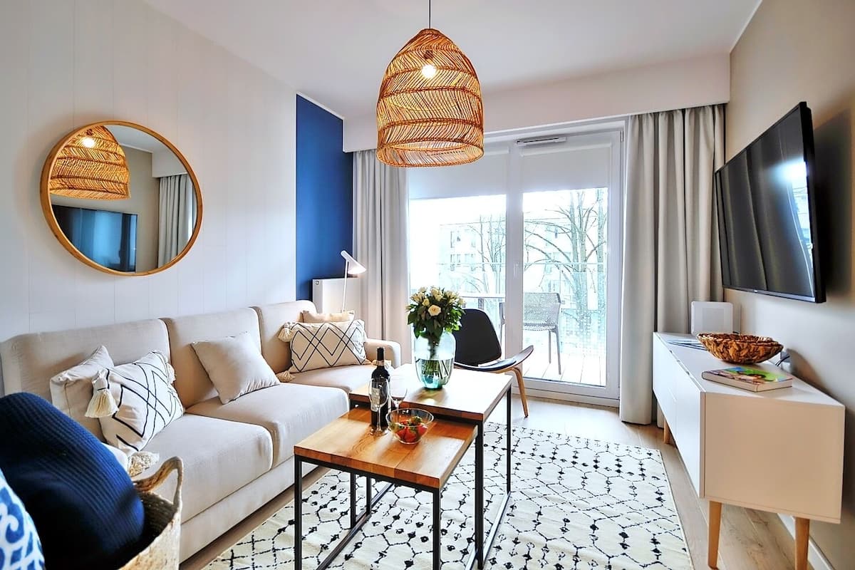 Ein modernes Wohnzimmer mit Sofa, Couchtisch und Fernseher.