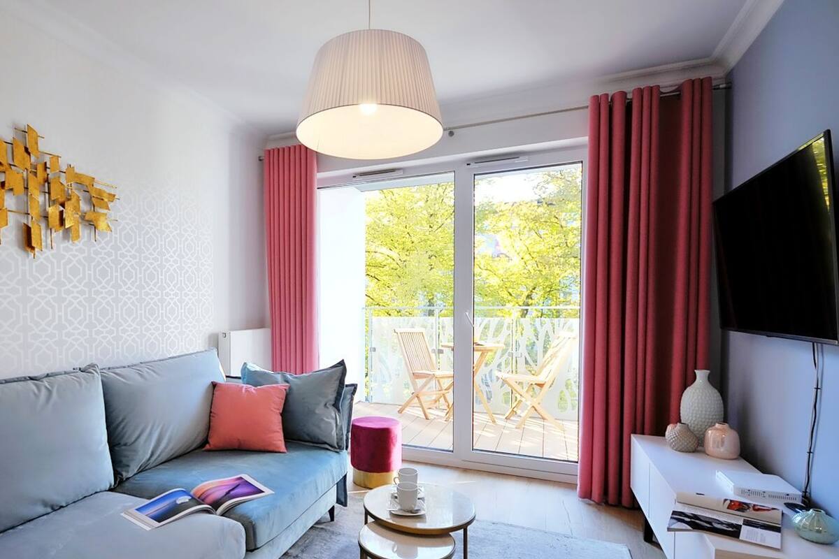 Ein modernes Wohnzimmer mit einem grauen Sofa, einem Couchtisch und einem Fernseher auf einem Lowboard.