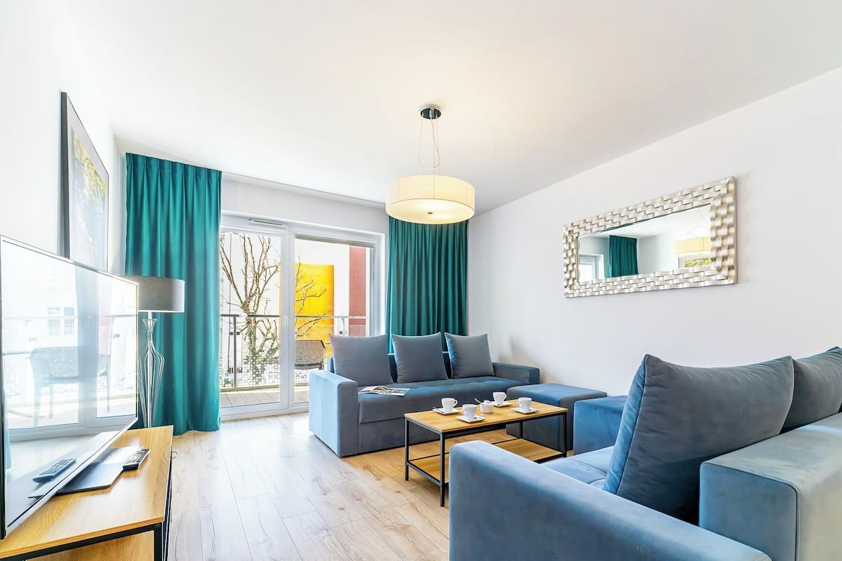 Ein modernes Wohnzimmer mit einer Couch, einem Couchtisch und einem Fernseher.