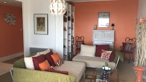 A living room with a sofa, armchairs, a coffee table, and a bookshelf. - Very bright F2 with terrace and panoramic view of the Port <br> (Sète)