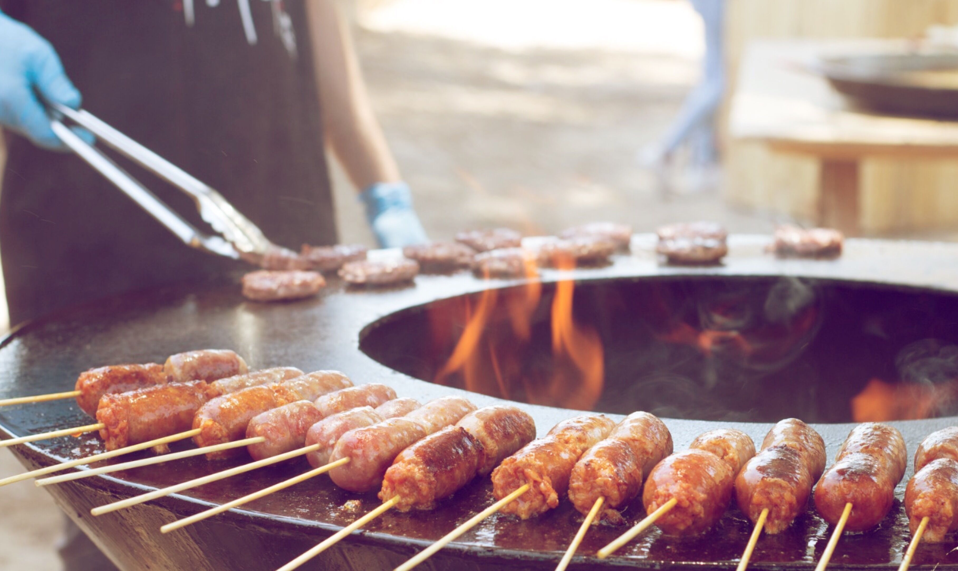 Una parrilla con salchichas cocinándose.