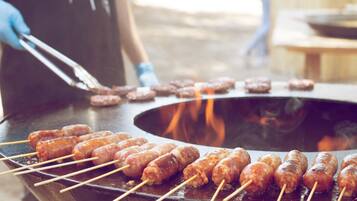 Una parrilla con salchichas cocinándose.