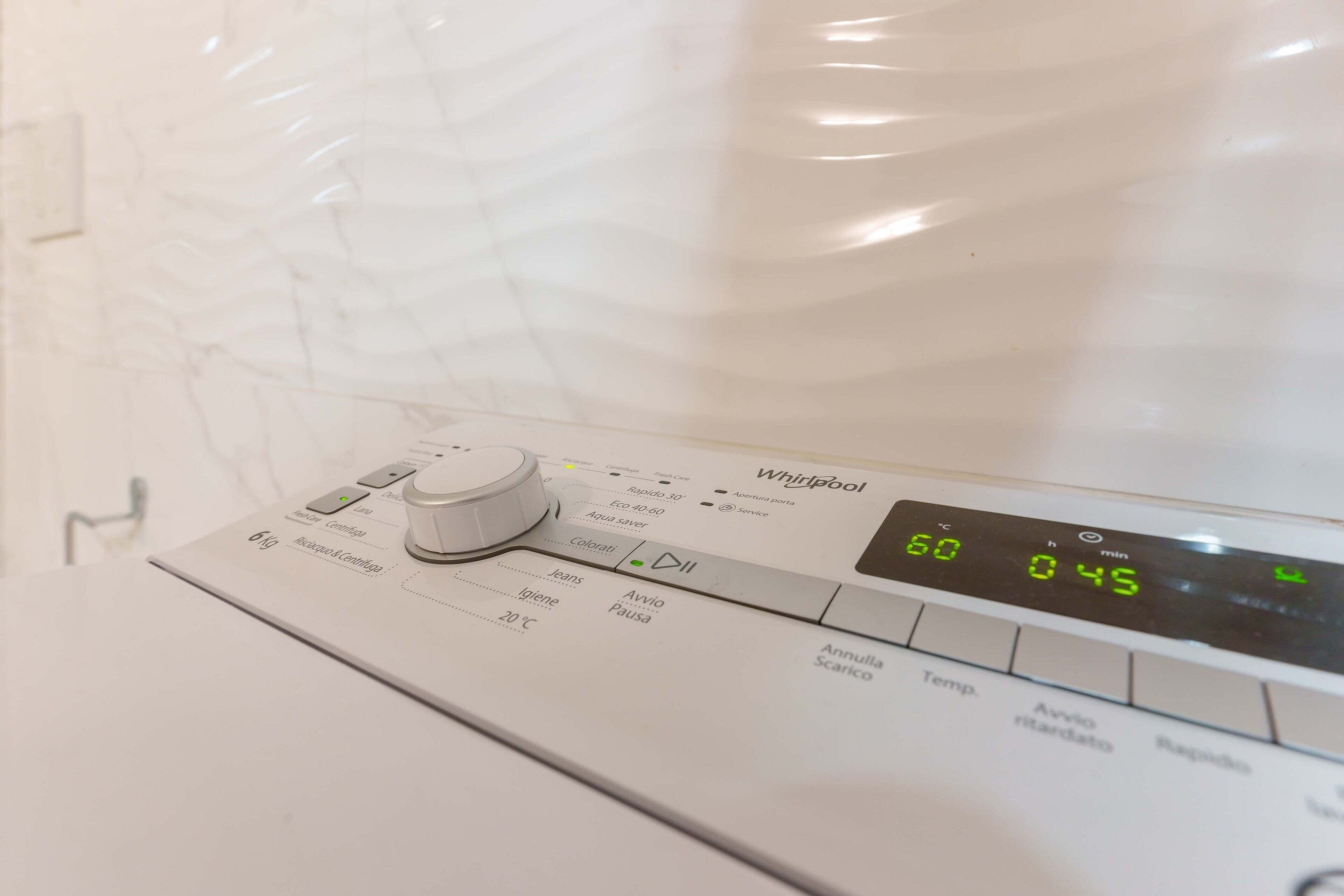 Un lave-linge Whirlpool doté d’un écran numérique indiquant 60 °C et 45 minutes.