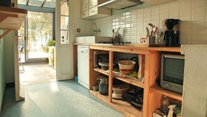 A kitchen with a wooden countertop, a stove, a sink, and a television. - Villa Suzanne terrace and veranda near the beach (Longeville-sur-Mer)