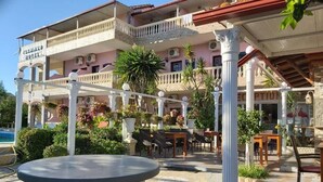 A hotel with a pool, outdoor seating, and a covered patio area. - Flamingo Apartments by CorfuEscapes (Corfu)