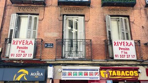 A building with two signs advertising 'RIVERA Pension' with a phone number. - Pension Rivera (Madrid)