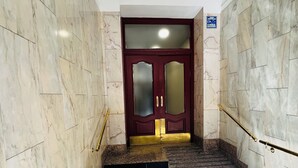 A marble staircase with a red door at the top. - Pension Rivera (Madrid)