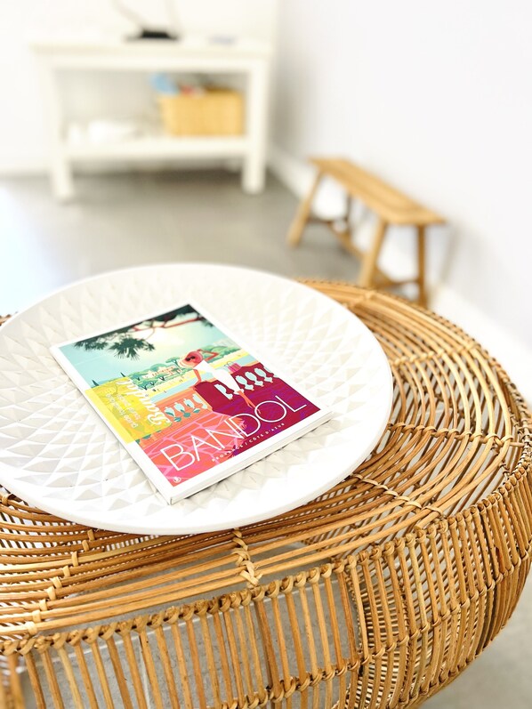 A wicker chair with a white plate and a colorful magazine on it.