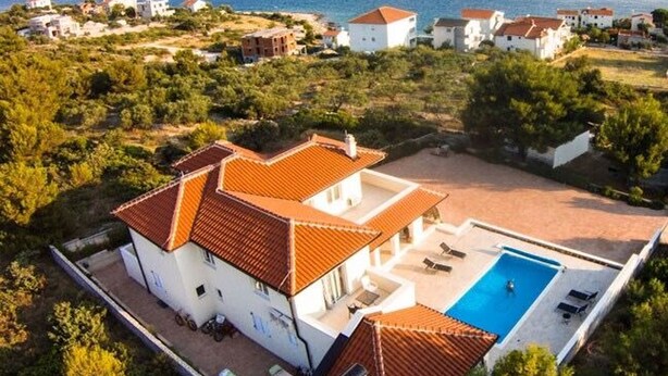 A large house with a swimming pool, surrounded by greenery and a view of the sea. - Apartments Lanterna (Rogoznica)
