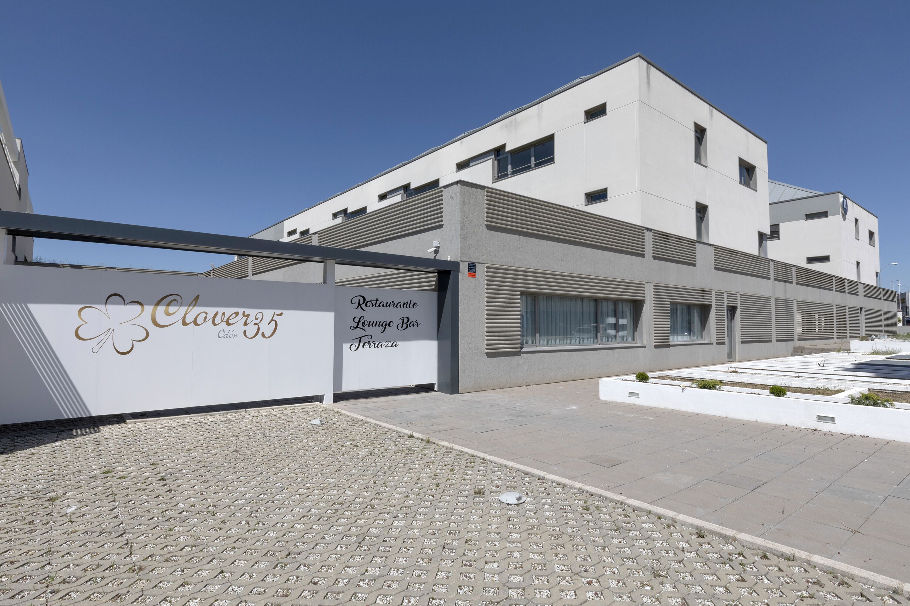 Un bâtiment moderne avec une enseigne indiquant « Clover 35, restaurant, salon et bar ».