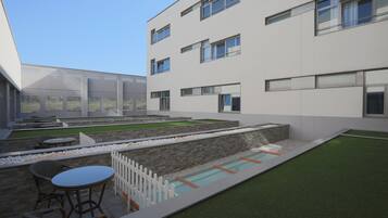 Un edificio moderno con amplias ventanas, piscina y zonas de estar al aire libre.