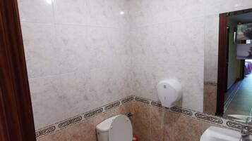 Un baño con inodoro, bidé y lavabo.