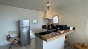 A compact kitchen with a refrigerator, a wooden island, and a microwave. - Beautifully furnished flats with sea view (Lecci)