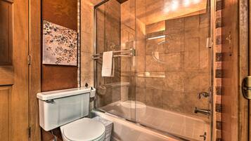 Un baño moderno con ducha de vidrio, inodoro y bañera.