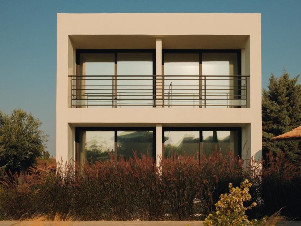 A modern two-story building with large windows and a balcony.