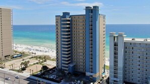 Ein Hochhaus-Hotel mit mehreren Etagen, Blick auf den Strand und einem Parkplatz.