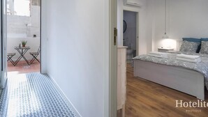 A modern hotel room with a bed, bedside table, lamp, and a view of the outside. - Hotelito Boutique Camp Nou 2 (Hospitalet de Llobregat, Barcelona)