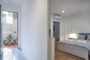 Un dormitorio con cama, mesita de noche y lámpara colgante.