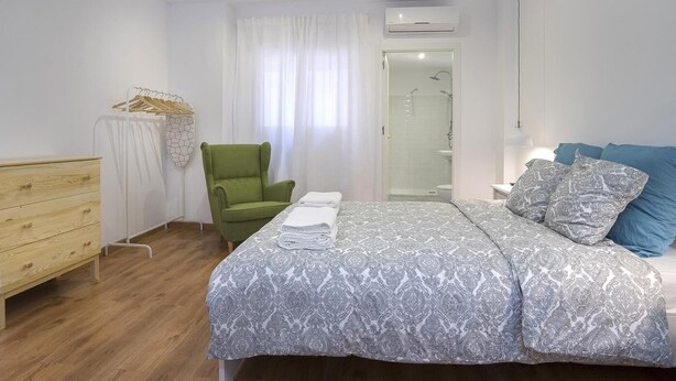 A bedroom with a bed, a chair, a dresser, and a shower area. - Hotelito Boutique Camp Nou 2 (Hospitalet de Llobregat, Barcelona)