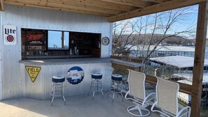 A bar area with a Miller sign, a yield sign, and outdoor seating.
