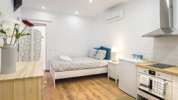 Tabla de planchar con plancha, internet y ropa de cama