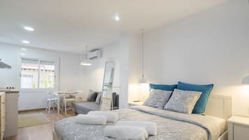 Ein modernes Schlafzimmer mit einem großen Bett, Nachttischen, einem Schreibtisch und einem Stuhl.
