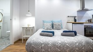 Ein Schlafzimmer mit Bett, Nachttisch und kleinem Schreibtisch.