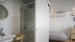 Ein modernes Badezimmer mit einer Glasdusche, einem Waschbecken und einem Spiegel.