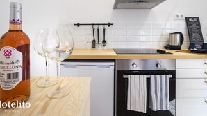 A modern kitchen with a wine bottle, glasses, a kettle, and a menu board. - Hotelito Boutique Cinca 4 (Hospitalet de Llobregat, Barcelona)