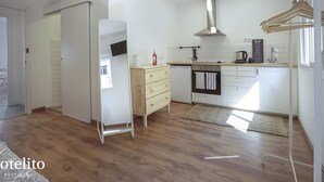 A modern kitchen with white cabinets, a stainless steel range hood, and a wooden countertop. - Hotelito Boutique Cinca 4 (Hospitalet de Llobregat, Barcelona)