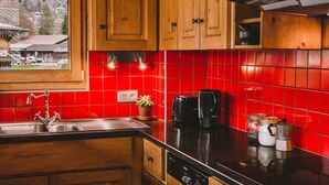 A kitchen with wooden cabinets, a red tiled backsplash, a Bosch dishwasher, and a coffee maker.