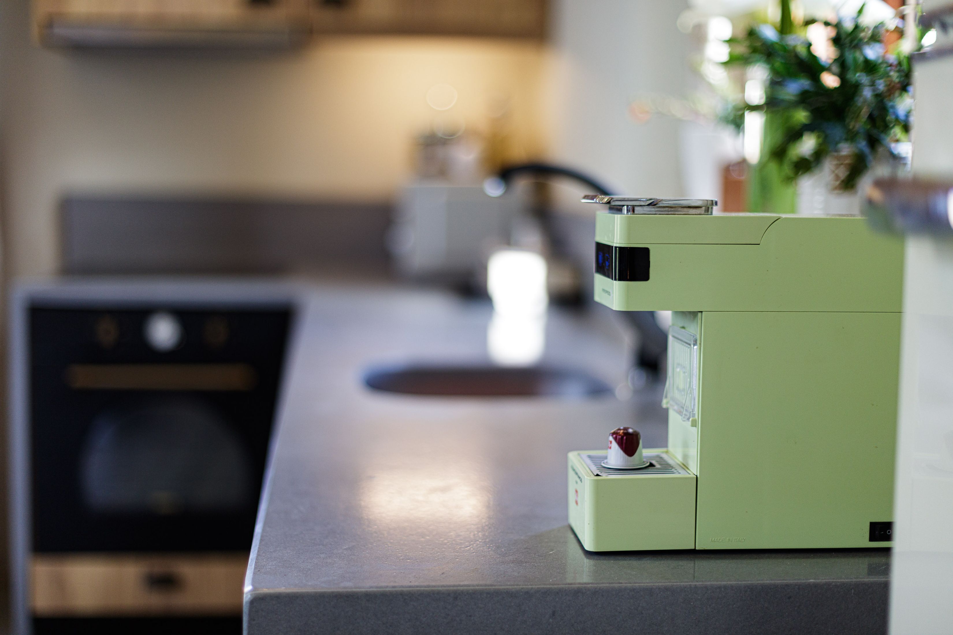 A kitchen with a modern espresso machine on a countertop.