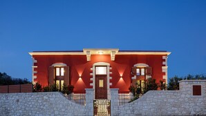 Ein modernes Gebäude mit roter Fassade, Steinwänden und einem zentralen Eingang mit Tür und Fenstern.