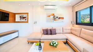 A modern living room with a sectional sofa, a coffee table with a bouquet, and artwork on the walls.