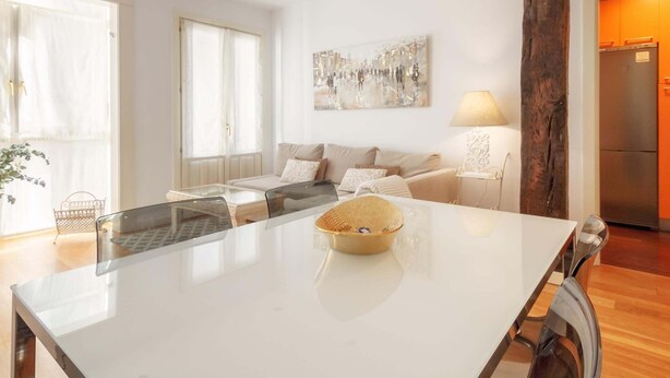 A modern kitchen with a central island, a dining table, and a sofa in the living area. - Old Town Center: Origins and Tradition. (Bilbao)